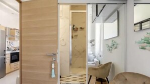 Un interno moderno con una porta in legno che conduce a una cucina e un bagno.