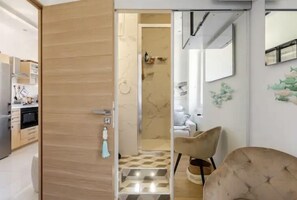 Een modern interieur met een houten deur naar een keuken en een badkamer.