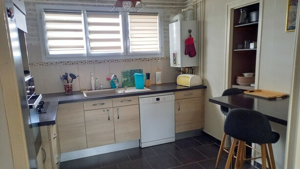 A compact kitchen with a dishwasher, a sink, and a window with blinds. - La douceur de vivre (Blois)