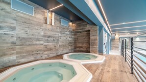 A spa area with two hot tubs and a wooden wall. - Seaside Apartamenty Kasprowicza (Kolobrzeg)