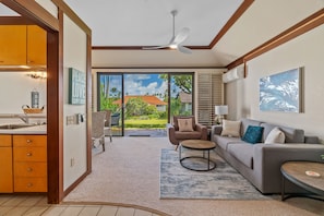 Enjoy a spacious open-plan living space with a kitchen and seating area, featuring a sofa, coffee table, and comfortable chair.
