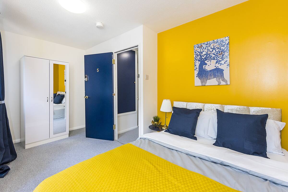 A room with a bed, a wardrobe, and a door.