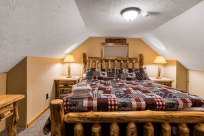 A bedroom with a wooden bed, a quilt, two bedside lamps, and a ceiling light. - Private Dock, Hot Tub, Fireplace, Lakefront, Large flat yard (McHenry)