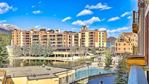 A multi-story hotel with balconies, a swimming pool, and a view of a mountain range. - Luxury 4 Bedroom Penthouse Rental off Main Street Within Walking Distance to Peak 9 (Breckenridge)