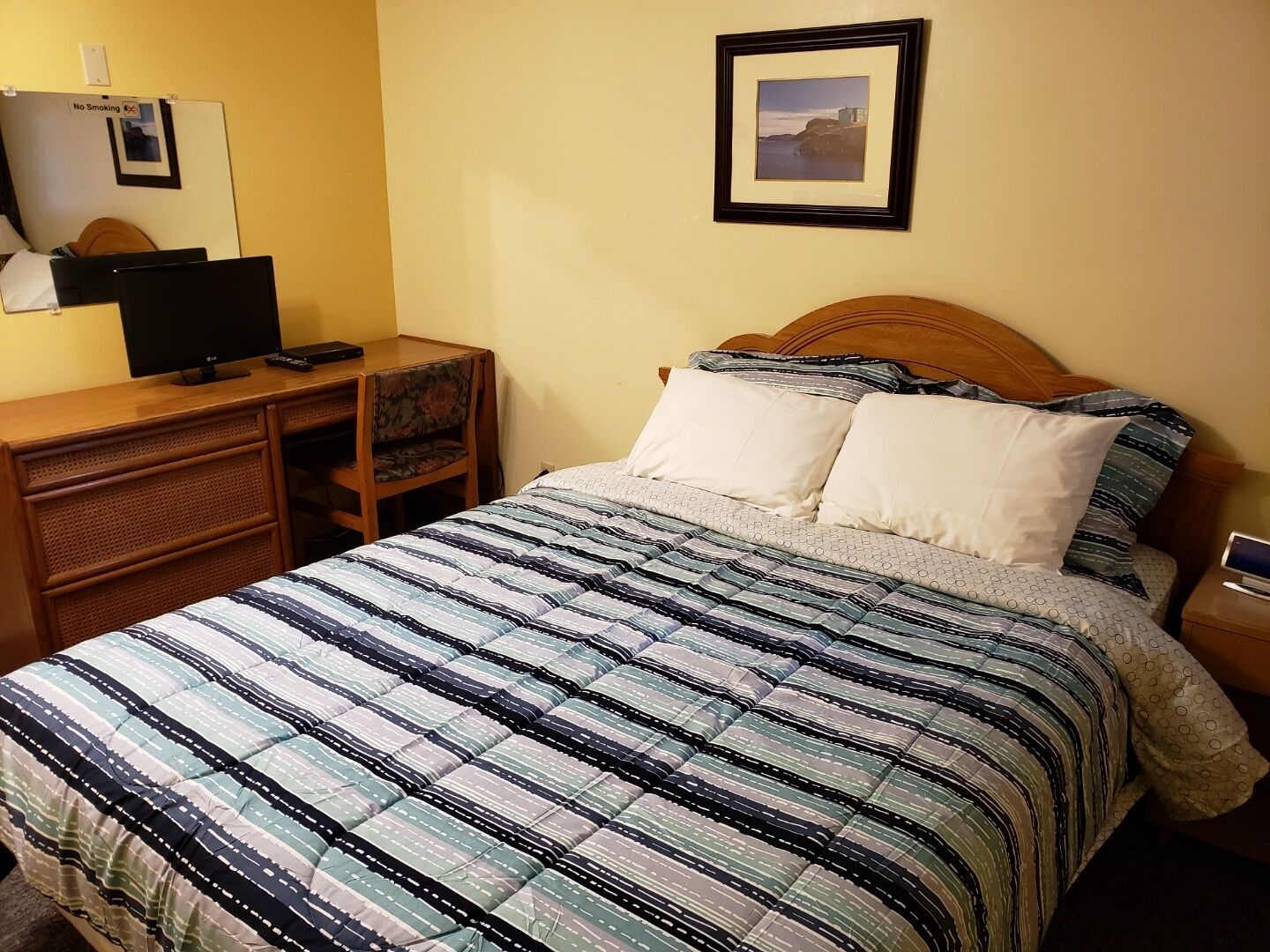 A bedroom with a bed, a desk, and a chair.