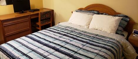 Ein Schlafzimmer mit Bett, Schreibtisch und Stuhl.