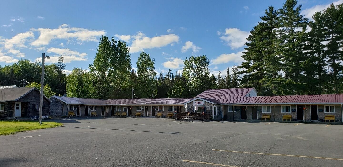 A motel with multiple rooms, a central office, and a parking lot.