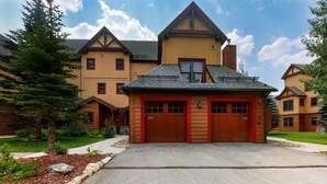 A two-story house with a garage, a sloped roof, and a stone pathway leading to the entrance. - Red Hawk Townhomes 2 Bedroom Rental in River Run Village (Keystone)
