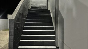 Unos escalones de hormigón conducen a la entrada de un edificio de noche.