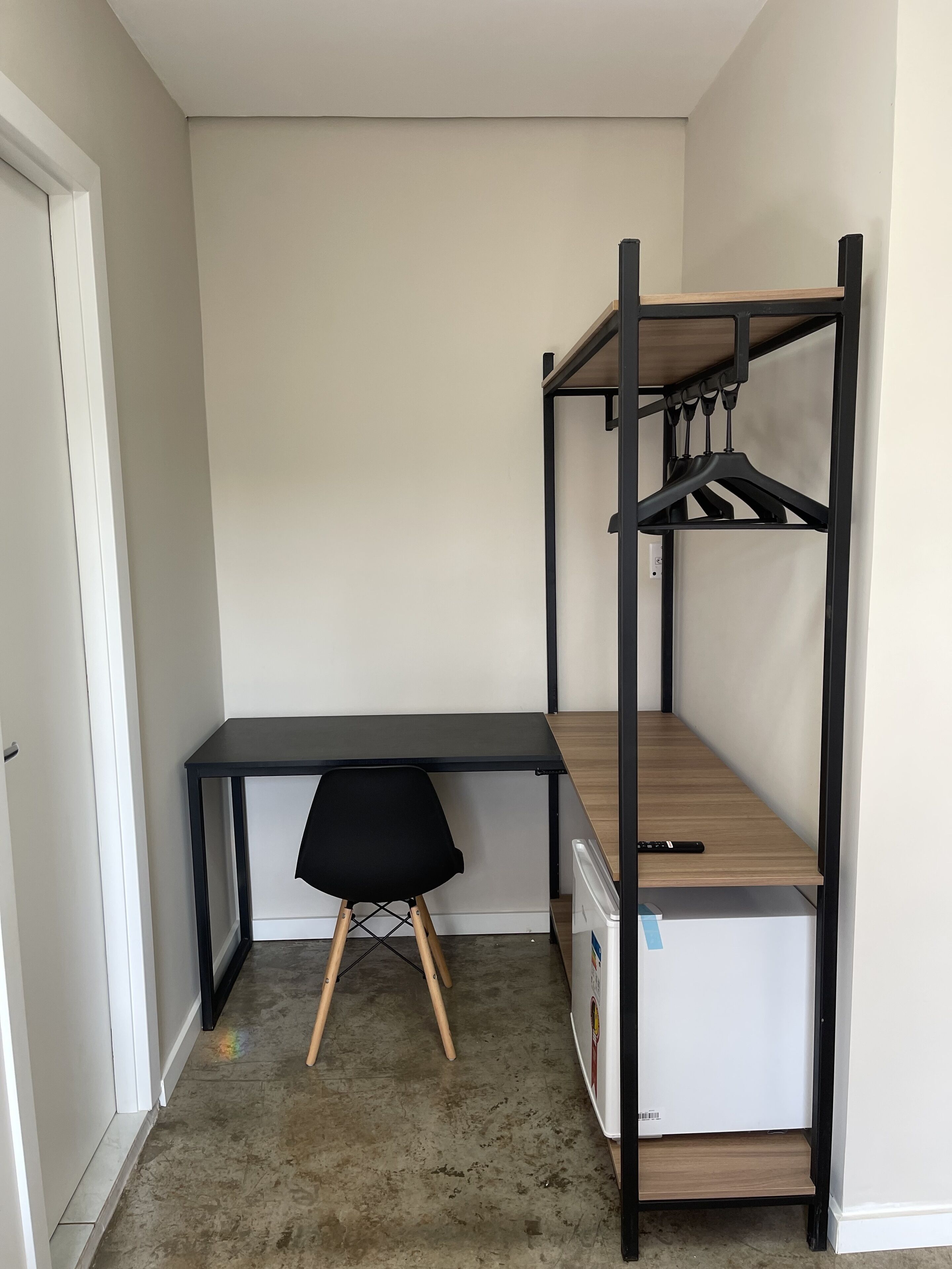 A compact room with a bunk bed, a desk, and a chair.