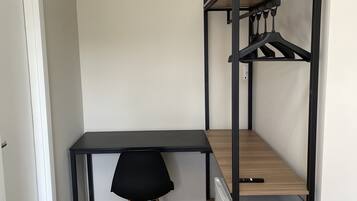 A compact room with a bunk bed, a desk, and a chair.