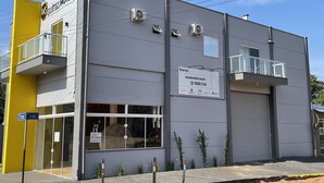 Un moderno edificio de hotel con fachada gris, balcones e indicación de disponibilidad para reservas.