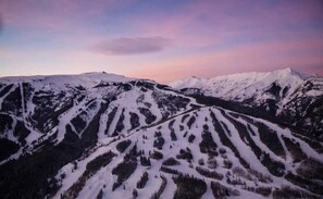 Un paysage montagneux aux pentes enneigées, sous un ciel dégagé.