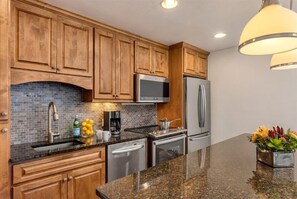 Fully equipped kitchen with a sink, microwave, refrigerator, dishwasher, and coffee maker.