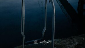 A calm river with a dock and a boat. - The Heights & Hollows Farmhouse (Downpatrick)
