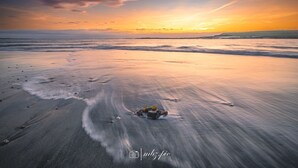 A beach with a sunset and calm waves. - The Heights & Hollows Farmhouse (Downpatrick)