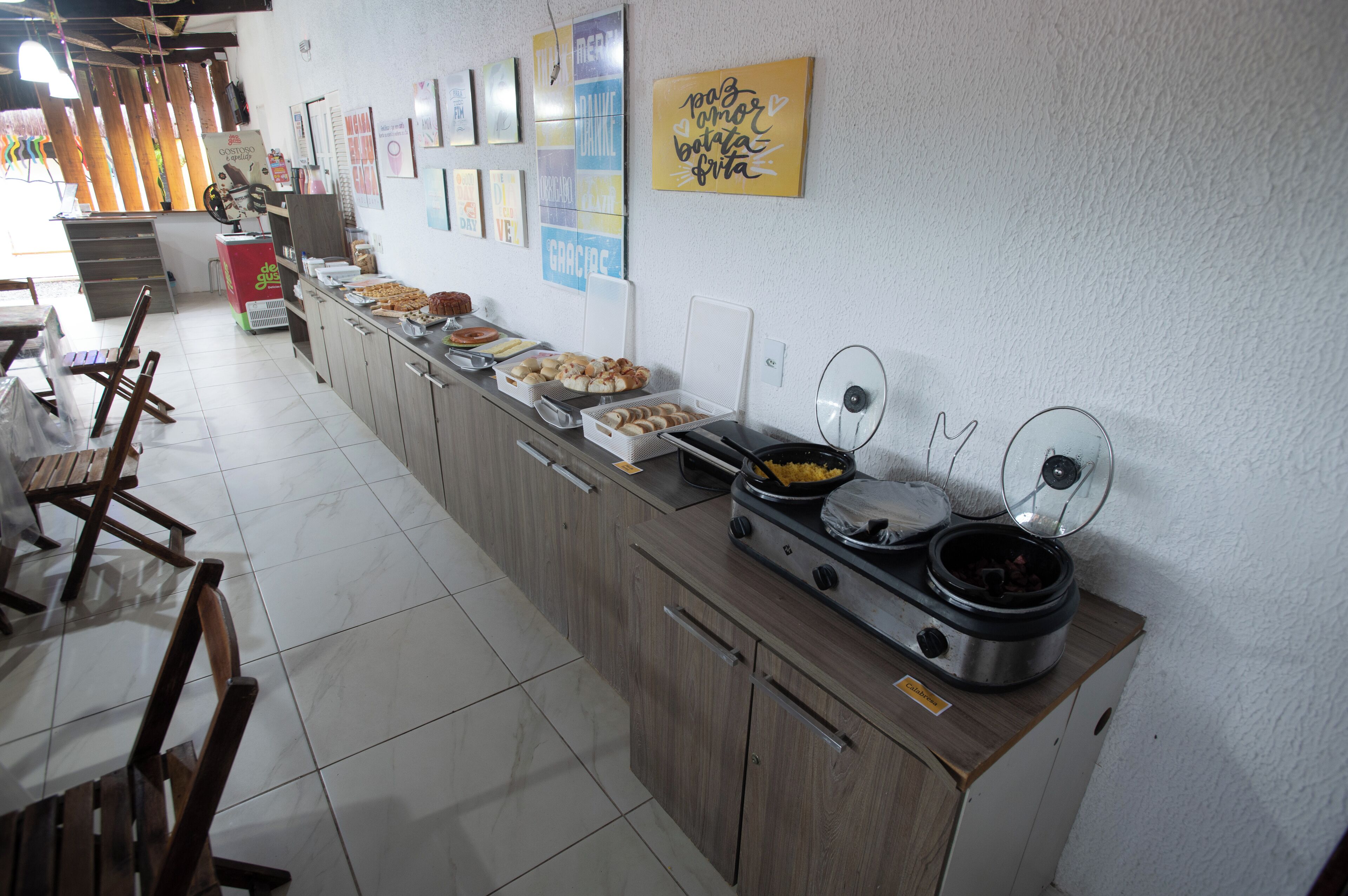 Un buffet proposant une variété de plats, une machine à café et un réfrigérateur.