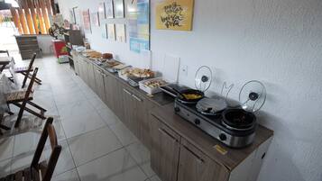 Un buffet proposant une variété de plats, une machine à café et un réfrigérateur.