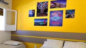 A hotel room with two beds, a large window, and a wall decorated with travel-themed posters. - POUSADA SUMMER BEACH BY AFT (Ipojuca)