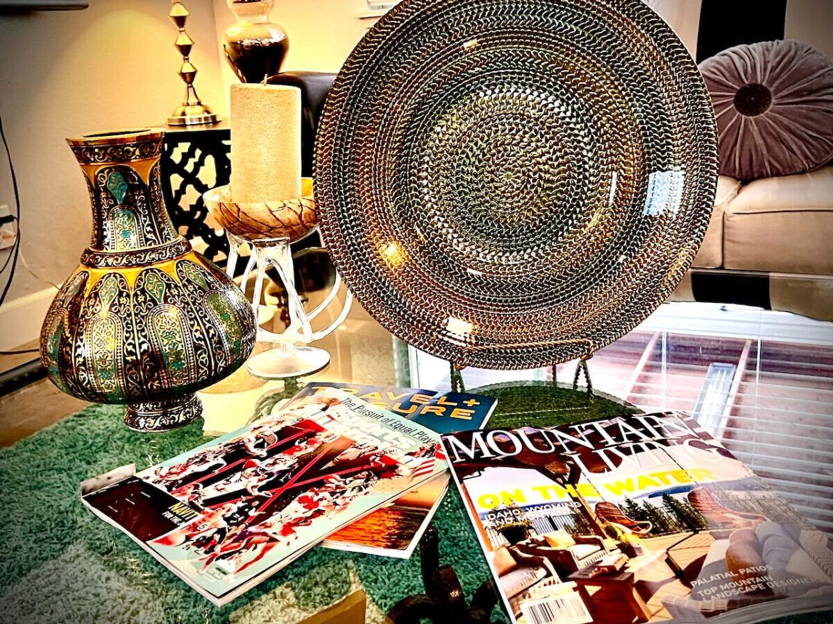 A table with decorative items, magazines, and a lamp.