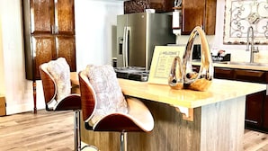 Una cocina moderna con una isla central, electrodomésticos de acero inoxidable y armarios de madera.