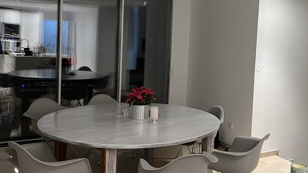 A modern dining area with a round table, six chairs, and a glass partition. - Luxurious sea view villa for 6 people, 1km from the beach (Marbella)