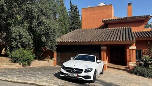 A white car parked in front of a building with a tiled roof and a brick wall. - Luxurious sea view villa for 6 people, 1km from the beach (Marbella)