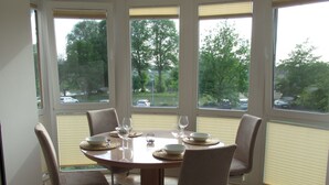 A dining area with a round table set for four, surrounded by chairs.