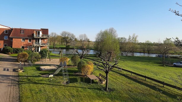 A residential area with a park, a pond, and a building with a red roof.