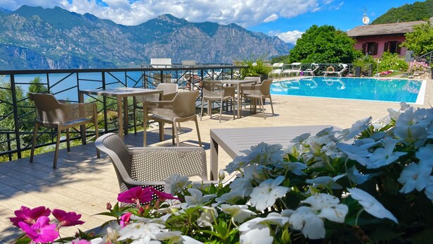 A terrace with outdoor seating, a pool, and a mountain view. - Casa di Alessia THE new vacation apartment with dream view over Malcesine incl. pool (Malcesine)