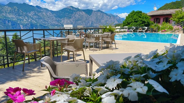 A terrace with outdoor seating, a pool, and a mountain view.