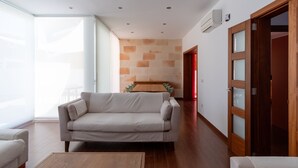 A modern living room with a sofa, a wooden coffee table, and a dining table with chairs. There is a sliding glass door leading to a balcony. - Villa Houses - Villa Alta Calidad con Piscina y Jardín. A 5 Minutos de la Playa (Ciutadella de Menorca)