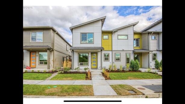 A row of modern townhouses with a 'SOLD' sign, featuring a mix of neutral and yellow colors, and a well-maintained front yard. - Comfy Cool Condo 5min from McMenamins Edgefield &10min from Columbia River Gorge (Troutdale)