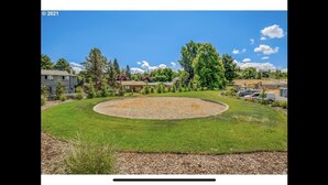A landscaped area with a circular lawn, trees, and a building in the background. - Comfy Cool Condo 5min from McMenamins Edgefield &10min from Columbia River Gorge (Troutdale)