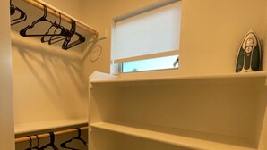 A walk-in closet with shelves for folded towels and a rack for hanging clothes. - Comfy Cool Condo 5min from McMenamins Edgefield &10min from Columbia River Gorge (Troutdale)