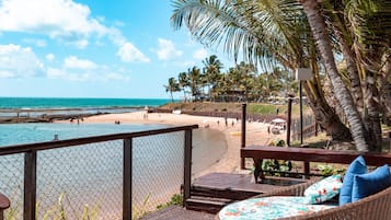 Na praia, areia branca, espreguiçadeiras, guarda-sóis