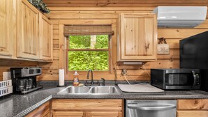 A kitchen with wooden cabinets, a coffee maker, a sink, a microwave, and a dishwasher.