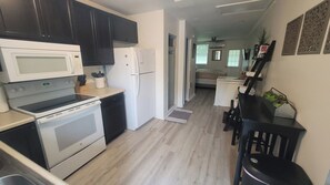 Een magnetron, een kookplaat, kookgerei, borden en bestek, kruiden