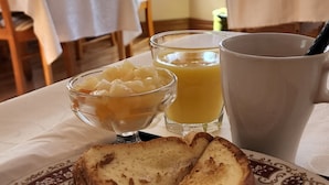 A breakfast plate with toast, sausages, bacon, and a fried egg. There are two glasses of orange juice on the table. - Anna's Bed & Breakfast (Niagara Falls)