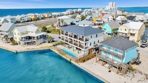 Un quartier résidentiel situé sur la côte, avec des maisons, une piscine et une plage.