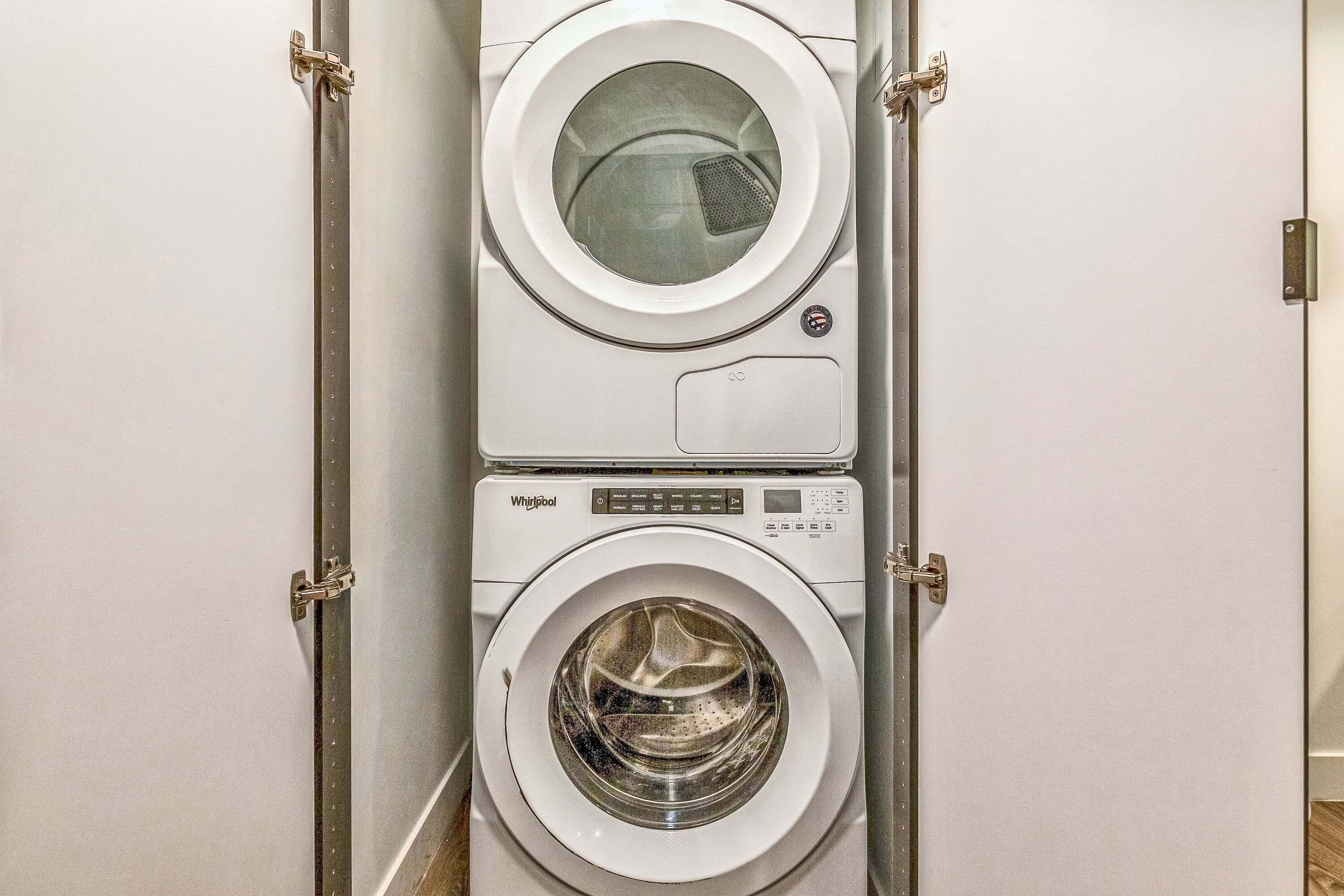 A stacked washer and dryer unit in a laundry room.