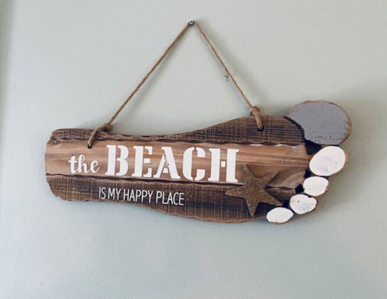 Une pancarte en bois sur laquelle on peut lire : « LA PLAGE EST MON ENDROIT PRÉFÉRÉ » et qui est ornée d’une étoile.