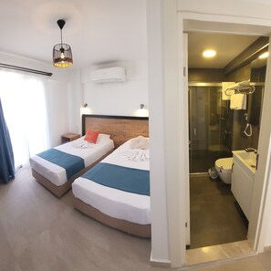 A hotel room with two beds, a shower, and a toilet. - Picasso Suites Cesme (Cesme)