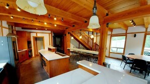 A modern kitchen with a marble countertop, wooden beams, and a dining area with bar stools.