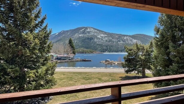 A wooden deck overlooking a lake with mountains in the background. - Newly Renovated from Top to Bottom! (Grand Lake)