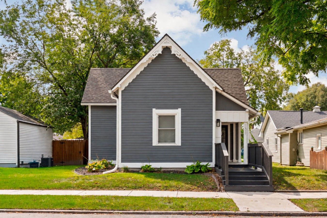 A residential house with a gabled roof, a front porch, and a small front yard.