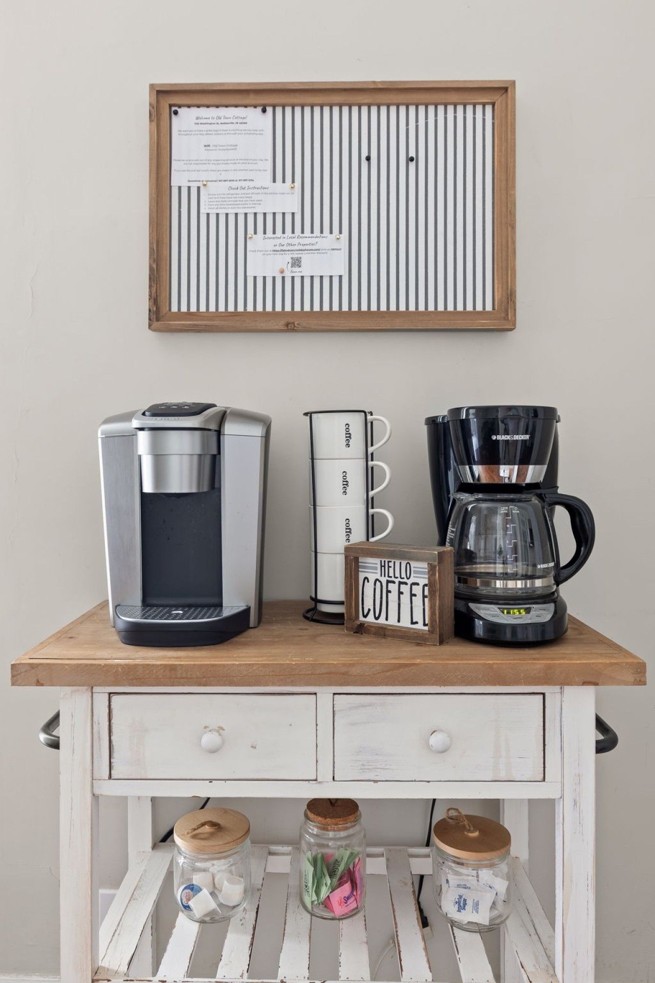 Un coin café équipé d’une machine à café, d’un porte-tasses et d’une pancarte sur laquelle est écrit « BONJOUR CAFÉ ».