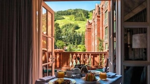 A dining table with breakfast items and a scenic view of a green landscape.