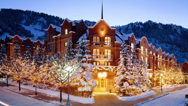A large, multi-story hotel with a prominent central tower and a snow-covered landscape in the background.