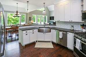 Modern kitchen with a large island, stainless steel sink, and gas stove.